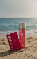 Smilelab whitening strips and mouth rinse on a sandy beach with ocean in the background